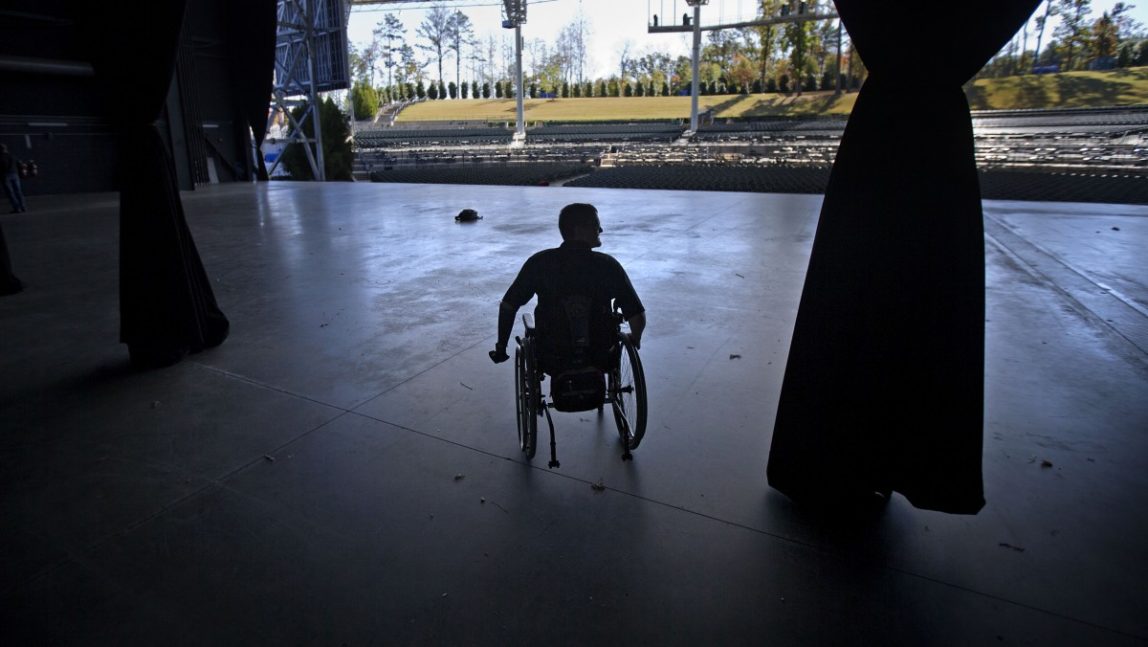 Cpl. Todd Love, rolls his wheelchair on stage while touring an amphitheater with fellow veteran Spc. Michael Schlitz, not pictured, before a benefit concert in the their honor Wednesday, Oct. 31, 2012, in Alpharetta, Ga. Cpl. Love lost both legs and his left arm in an IED explosion in Afghanistan. (AP Photo/David Goldman)