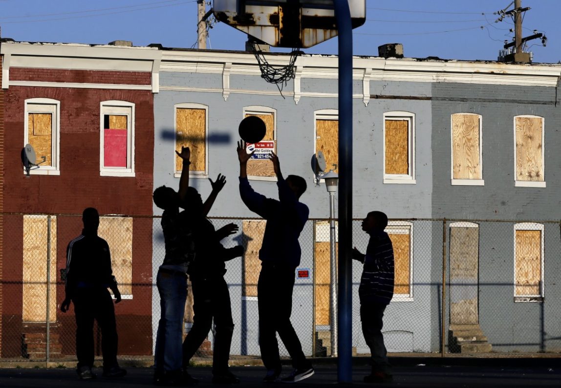 Children play basketball at a park near blighted row houses in Baltimore, Monday, April 1, 2013. Americans are experiencing poverty at levels not seen since the mid-1960. (AP Photo)