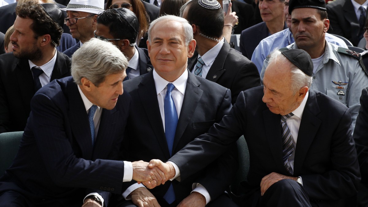 Israeli President Shimon Peres, right, shakes hands with U.S. Secretary of State John Kerry, left, as Prime Minister Benjamin Netanyahu sits between them during the annual ceremony marking Holocaust Remembrance Day at the Yad Vashem memorial in Jerusalem, Israel (AP/Gali Tibbon)