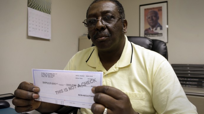 Wayne Bostic holds his last pay-stub dating back over two years in Raleigh, N.C., on June 19, 2013. Bostic lost his job and has been collecting extended unemployment benefits. Changes that North Carolina has made in unemployment has disqualified the state's unemployed, like Bostic, from receiving federal benefits that kick in after the state benefits run out. Bostic volunteers at the A. Philip Randolph Institute Inc., a non-profit community outreach program. (AP/Gerry Broome)