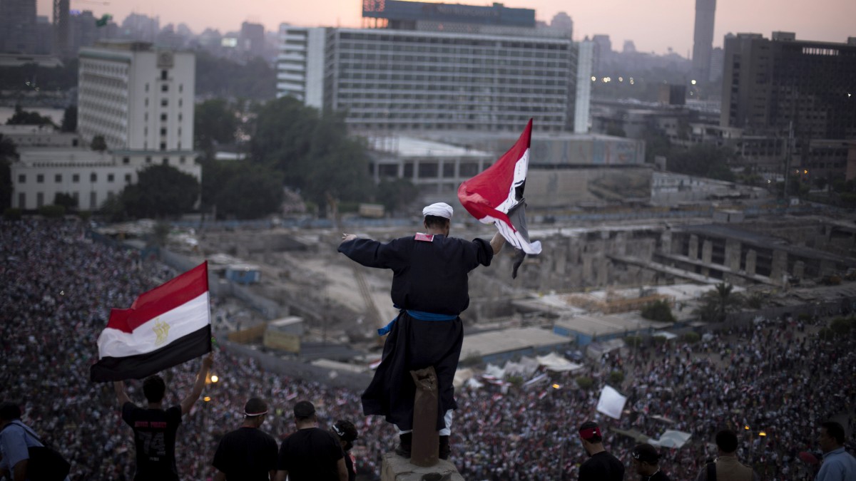 An Egyptian protester waves a national flag in Tahrir Square during a demonstration against Egypt's President Mohammed Morsi in Cairo, Monday, July 1, 2013. (AP/Manu Brabo)