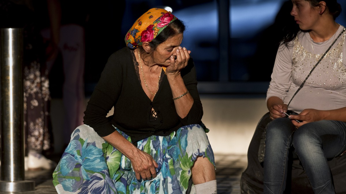 Roma women expelled from France sit on the pavement at Bucharest's Henri Coanda international airport in Otopeni, Romania, Thursday, Sept. 13, 2012. (AP/Vadim Ghirda)