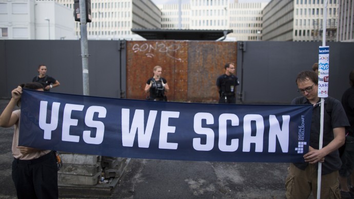 Demonstrators hold a banner during a protest against the supposed surveillance by the US National Security Agency, NSA, and the German intelligence agency, BND, during a rally in front of the construction site of the new headquarters of German intelligence agency in Berlin, Germany, Monday July 29, 2013. (AP/Gero Breloer)