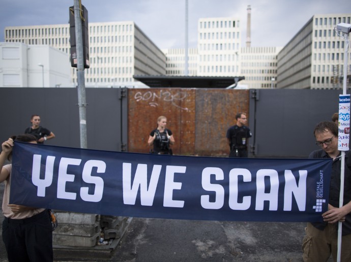 Demonstrators hold a banner during a protest against the supposed surveillance by the US National Security Agency, NSA, and the German intelligence agency, BND, during a rally in front of the construction site of the new headquarters of German intelligence agency in Berlin, Germany, Monday July 29, 2013. (AP/Gero Breloer)