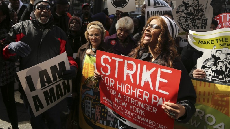 Demonstrators holds a sign and chant slogans outside of a Wendy's fast food restaurant, Thursday, April 4, 2013 in New York. Fast-food walkouts spread to Detroit on Friday, as workers demanded higher wages and the right to unionize. (AP Photo/Mary Altaffer)