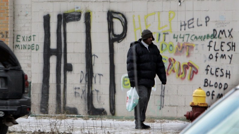 A pedestrian walks by graffiti in downtown Detroit. On Thursday, July 18, 2013 Detroit became the largest city in U.S. history to file for bankruptcy when State-appointed emergency manager Kevyn Orr asked a federal judge for municipal bankruptcy protection. (AP/Carlos Osorio)
