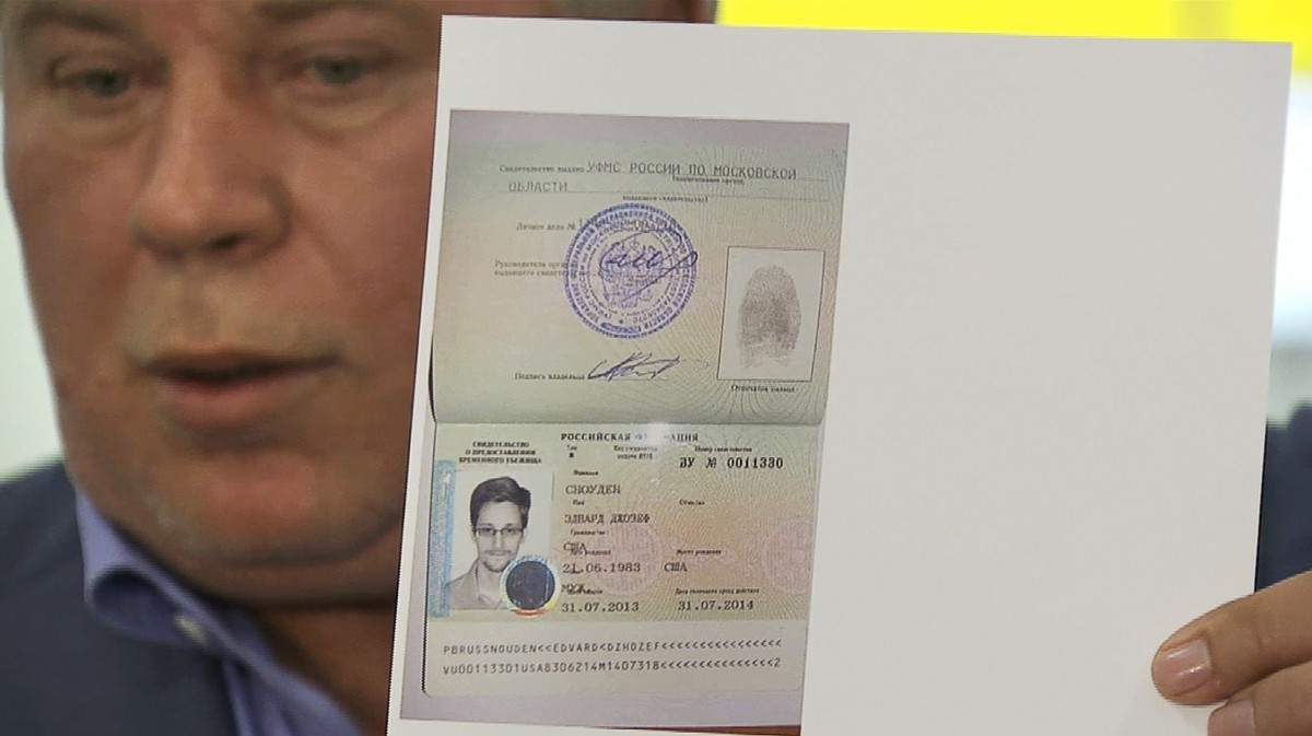 In this image taken from Associated Press Television shows, Russian lawyer Anatoly Kucherena showing a temporary document to allow Edward Snowden to cross the border into Russia while speaking to the media after visiting National Security Agency leaker Edward Snowden at Sheremetyevo airport outside Moscow, Russia, on Thursday, Aug. 1, 2013. (AP Photo/APTN)