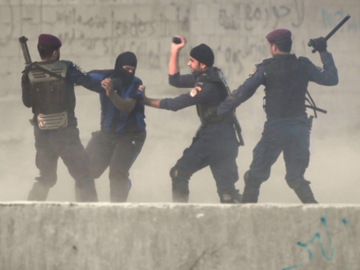 Riot police catch a Bahraini anti-government protester in the village of Shakhura, Bahrain, on, Aug. 14, 2013. (AP/Hasan Jamali)