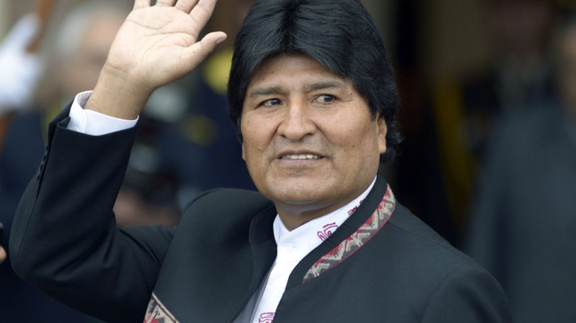 Bolivia's President Evo Morales waves to photographers as he arrives for the Mercosur trade bloc summit in Montevideo, Uruguay, Friday, July 12, 2013. Paraguay is expected to be readmitted into the bloc after member nations suspended its membership last year for having impeached and ousted President Fernando Lugo. (AP Photo/Matilde Campodonico)