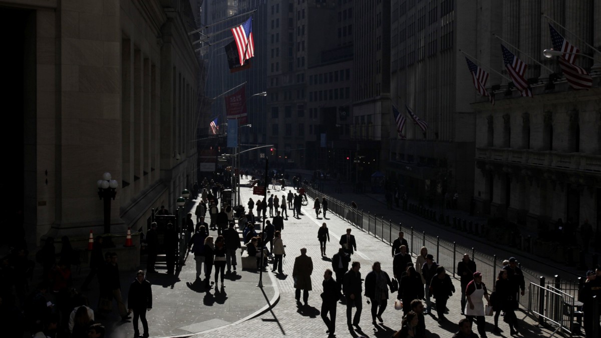 People walk in front of the New York Stock Exchange, in New York. (AP Photo/Seth Wenig)