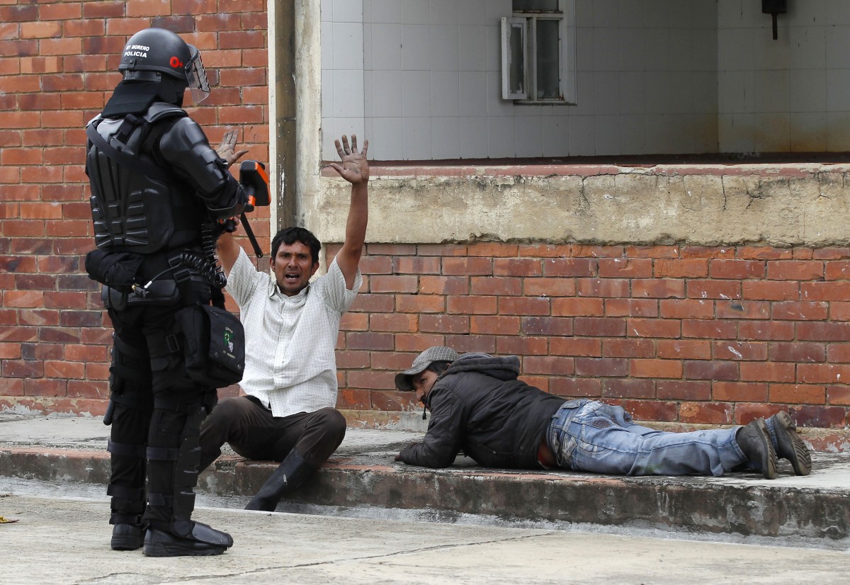 Riot police detain protesters in Ubate, north of Bogota, Colombia, Monday, Aug. 26, 2013. Hundreds of protesters clashed with police in support of farmers who have being blockading highways for a week for an assortment of demands that include reduced gasoline prices, increased subsidies and the cancellation of free trade agreements. (AP Photo/Fernando Vergara)