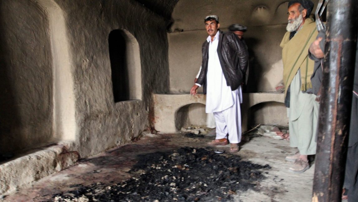 FILE - In this Sunday, March 11, 2012 file photo, men stand next to blood stains and charred remains inside a home where witnesses say Afghans were killed by a U.S. soldier in Panjwai, Kandahar province south of Kabul, Afghanistan. U.S. Army Staff Sgt. Robert Bales was charged on Friday, March 23, 2012 with 17 counts of premeditated murder, a capital offense that could lead to the death penalty in the massacre of Afghan civilians, the U.S. military said. (AP Photo/Allauddin Khan, File)