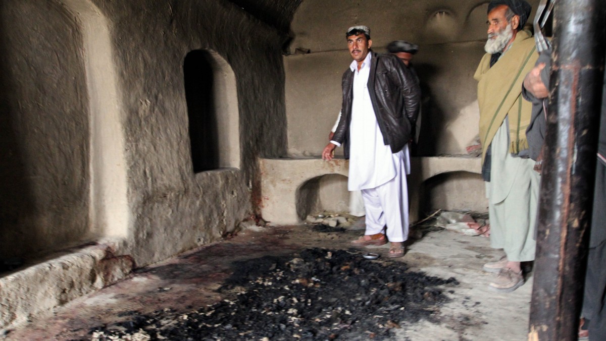 FILE - In this Sunday, March 11, 2012 file photo, men stand next to blood stains and charred remains inside a home where witnesses say Afghans were killed by a U.S. soldier in Panjwai, Kandahar province south of Kabul, Afghanistan. U.S. Army Staff Sgt. Robert Bales was charged on Friday, March 23, 2012 with 17 counts of premeditated murder, a capital offense that could lead to the death penalty in the massacre of Afghan civilians, the U.S. military said. (AP Photo/Allauddin Khan, File)
