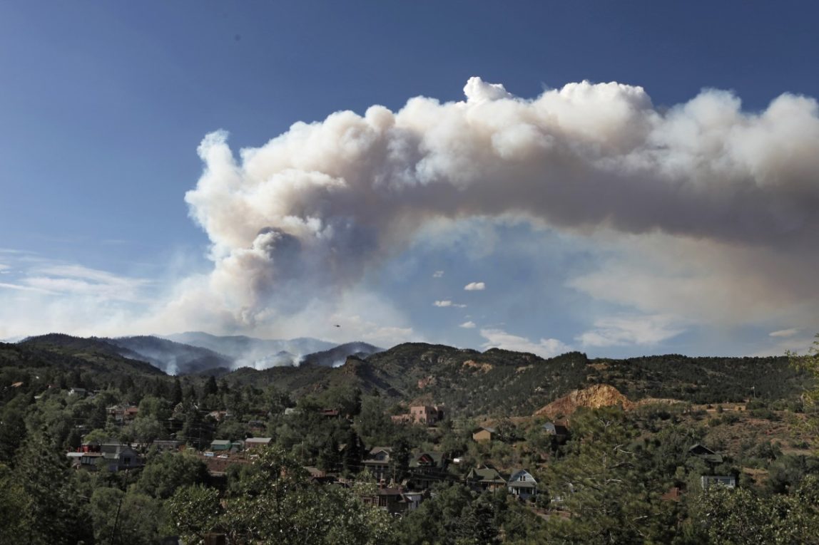 FILE- In this June 25, 2012, file photo, a plume of smoke rises above the Waldo Canyon wildfire west of Manitou Springs, Colo. The fire left behind vast swaths of scorched earth highly conducive to flash flooding. In Colorado, multiple flash floods have struck this summer in or near scars left by last years wildfires. The U.S. Forest Service spent nearly $46 million nationwide in fiscal 2012 on emergency erosion measures. (AP Photo/Ed Andrieski)