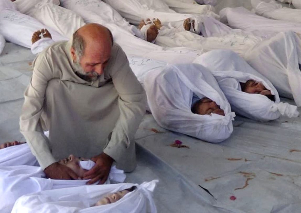 In this citizen journalism image provided by the Media Office Of Douma City, which has been authenticated based on its contents and other AP reporting, a Syrian man mourns over a dead body after an alleged poisonous gas attack fired by regime forces, according to activists, in Douma town, Damascus, Syria, Wednesday, Aug. 21, 2013. (AP Photo/Media Office Of Douma City)