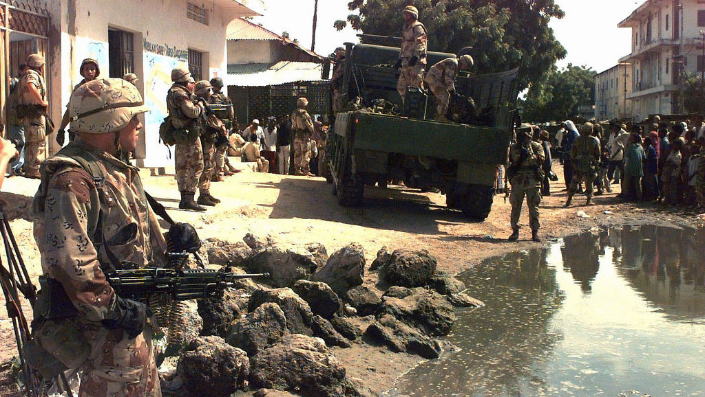 U.S. Marines load ammunition and weapons on a truck in Mogadishu, Somalia's, Bakara Market December 2006. A Marine stands holding a M60 machine gun, left, pointing it at a crowd of Somali civilians standing at the right. (Photo/Expert Infantry via Flickr)
