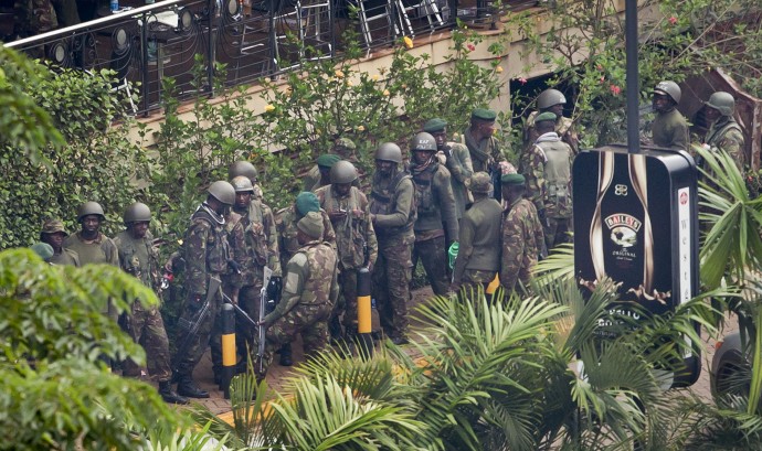 Soldiers from the Kenyan Defence Forces gather at the entrance to the Westgate Mall in Nairobi, Kenya Thursday, Sept. 26, 2013. Working near bodies crushed by rubble in a bullet-scarred, scorched mall, FBI agents began fingerprint, DNA and ballistic analysis Wednesday to help determine the identities and nationalities of victims and al-Shabab gunmen who attacked the shopping center, killing more than 60 people. (AP Photo/Ben Curtis)