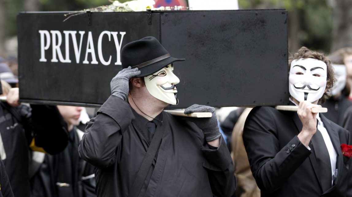 Protesters with Guy Fawkes masks protest with a replica of a coffin bearing the words "privacy" against data retention. (Photo: Ronald Zak / DAPD)