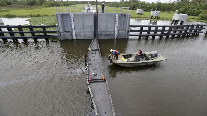 Workers lower a flood gate into Hero Canal, as part of the hurricane protection system protecting the greater New Orleans area, in anticipation of Tropical Storm Karen, in Belle Chasse, La., Friday, Oct. 4, 2013.  National Hurricane Center forecasters expect Karen to be near the central Gulf Coast on Saturday as a weak hurricane or tropical storm. Along with strong winds, the storm was expected to produce rainfall of 3 to 6 inches through Sunday night, with isolated totals up to 10 inches possible. Forecast tracks showed it possibly brushing, or crossing, the southeast Louisiana coast before veering eastward toward south Alabama and the Florida panhandle. (AP Photo/Gerald Herbert)