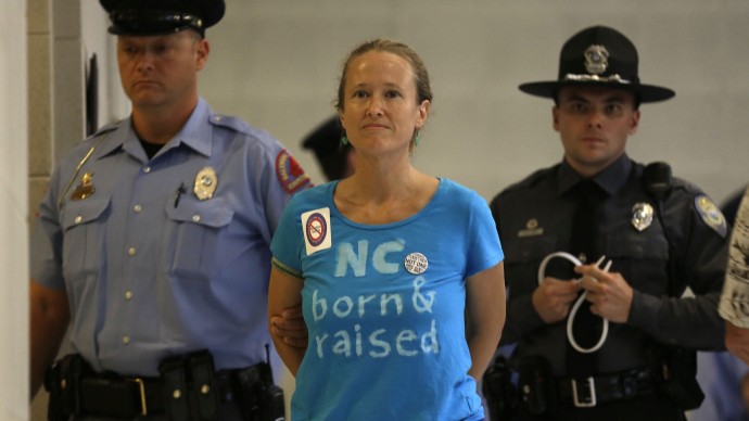 A woman is arrested outside the House and Senate chambers during "Moral Monday" protests at the General Assembly in Raleigh, N.C., Monday, June 24, 2013. Protesters are angry over the rightward direction of the state on economic, social, education and voting policy. They focused much of their demonstration on looming unemployment benefits cuts that will end extended benefits for about 70,000 people at the end of June. (AP Photo/Gerry Broome)