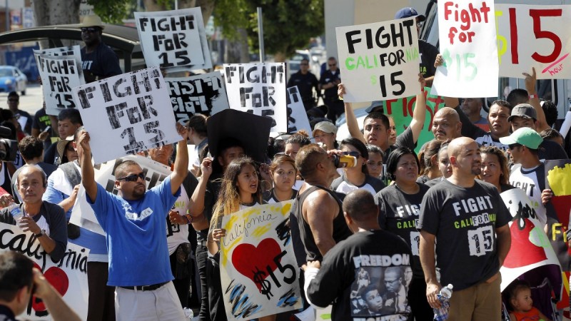 FILE - In this Aug. 29, 2013, file photo, protestors demonstrate outside a fast-food restaurant in Los Angeles. Thousands of fast-food workers and their supporters have been staging protests across the country to call attention to the struggles of living on or close to the federal minimum wage. The push raises the question of whether the economics of the fast-food industry allow room for a boost in pay for its workers. (AP Photo/Nick Ut, File)