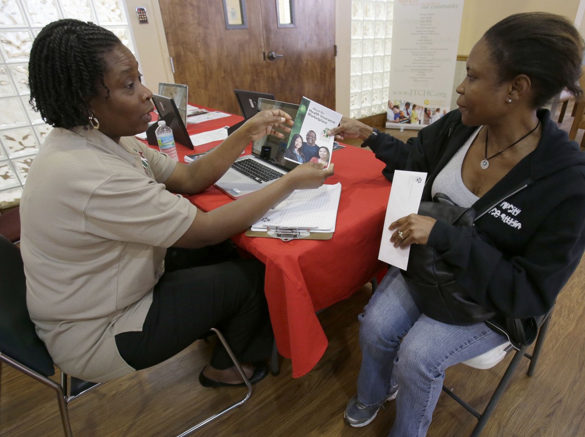 Suze Diogene, left, a certified application counselor, gives Audrey Allen information about health care, Tuesday, Oct. 1, 2013 at the Jessie Trice Community Health Center in Miami. Due to sporadic glitches in the system, counselors were mostly only able to give out information about the program and tell applicants to come back later when the system was operating. After months of build-up, The federal government is facing two major hurdles: fighting the confusion and misinformation surrounding the plan referred to as "Obamacare" and making sure the new technology systems function properly. (AP Photo/Wilfredo Lee)