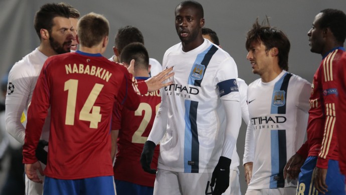In this photo taken on Wednesday, Oct. 23, 21013, Manchester City's Yaya Toure, center, listens to CSKA's Kirill Nababkin, left, during the Champions League group D soccer match between CSKA Moscow and Manchester City, at Arena Khimki stadium outside Moscow, Russia, on Wednesday, Oct. 23, 2013. Manchester City midfielder Yaya Toure called on UEFA to take action against CSKA Moscow after he was subjected to racist chanting during his team's 2-1 win in the Champions League. The Ivory Coast player said he had told match referee Ovidiu Hategan about the chants during the game in the Russian capital. (AP Photo/Ivan Sekretarev)
