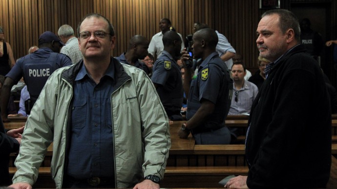 Afrikaner extremist group Boeremag co-leaders Andre du Toit, left, and his brother Mike du Toit, right, stands in the dock before their sentencing at High Court in Pretoria, South Africa, Tuesday, Oct. 29, 2013. A South Africa court handed members of a white extremist group sentences ranging from five to 35 years in prison, with years suspended, for various charges including high treason, murder and culpable homicide and conspiring to murder for a thwarted plan to kill Mandela in the country’s first post-apartheid treason trial. (AP Photo/Themba Hadebe)