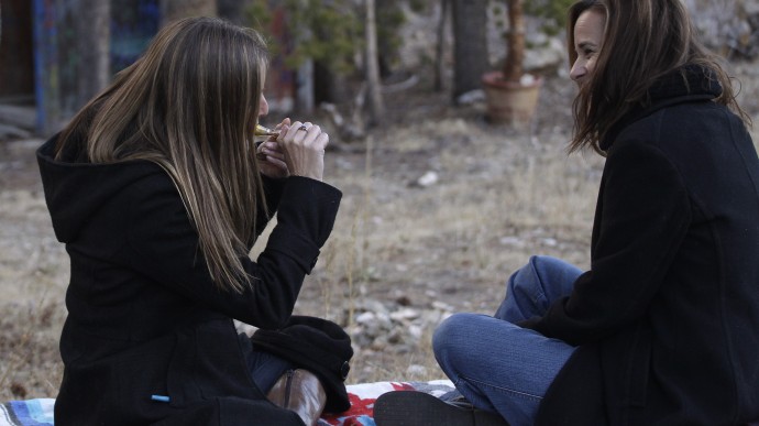 ADVANCE FOR USE MONDAY, DEC. 3, 2012 AND THEREAFTER - In this Nov. 19, 2012 photo, two women smoke marijuana together, behind a home in the woods near the small Rocky Mountain town of Nederland, Colo. On Nov. 6, 2012, Colorado and Washington state legalized the recreational use of marijuana. The two states, both culturally and politically, offered fertile ground for legalization advocates - Washington for its liberal politics, Colorado for its libertarian streak, and both for their Western independence. (AP Photo/Brennan Linsley)