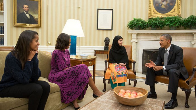 President Barack Obama, (far right), seated next to sixteen year old Pakistani girl Malala Yousafzai in the White House oval office, with First Lady Michelle Obama, (second from left), and daughter Malia Obama, (far left). (Photo/White House via WikimediaCommons)