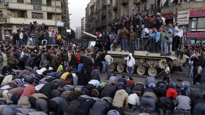 Egyptian anti-government protesters pray in front of an Egyptian army tank during a protest in Tahrir square in Cairo, Egypt, Saturday, Jan. 29, 2011. The years following the uprising have seen a growing divergence between Western spectators who had hoped for a secular, liberal revolution and the realities of Islamist parties winning many elections. (AP Photo/Ben Curtis)