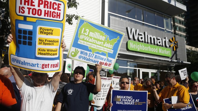 Protesters gather outside a Walmart Neighborhood Store for a peaceful demonstration Thursday, Sept. 5, 2013, in Chicago. A handful of protesters participated in an act of civil disobedience by standing in the street and then taken into custody and given misdemeanor tickets. (AP Photo/Charles Rex Arbogast)