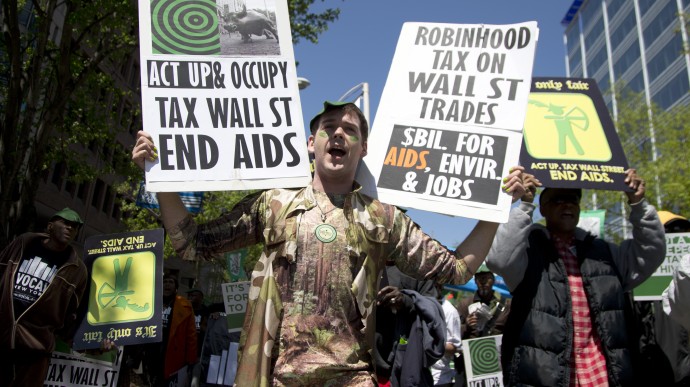 R.J. Barnett of New York marches with a crowd up Connecticut Ave. N.W., Saturday, April 20, 2013, in Washington, to demand support for the Robin Hood Tax, a financial transactions tax on Wall Street that they feel would solve the country's growing revenue crisis. (AP Photo/Carolyn Kaster)