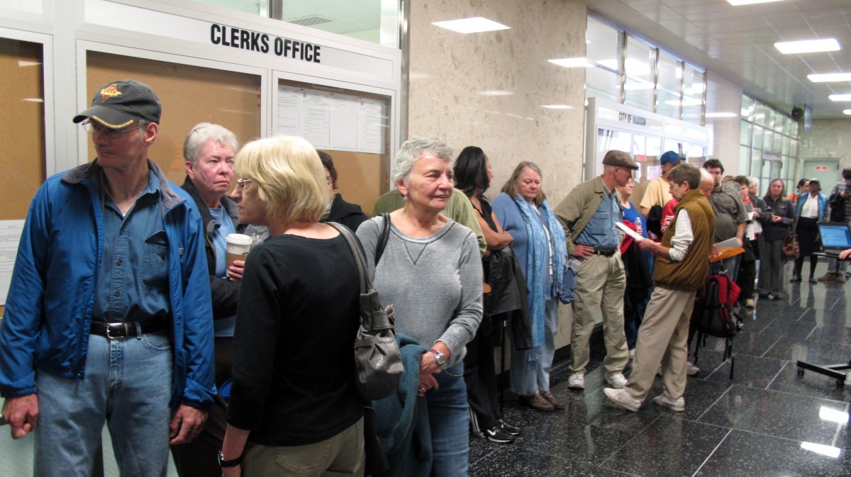 Voters line up outside the Madison city clerk's office to be among the first to cast ballots early for the Nov. 6 election on Monday, Oct. 22, 2012, in Madison, Wis. Wisconsin is one of just nine states where both President Barack Obama and Republican Mitt Romney are campaigning heavily as the election nears. (AP Photo/Scott Bauer)