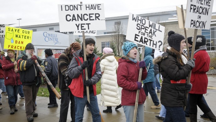 Anti-fracking protestors carry signs while protesting in front of The Covelli Center near downtown Youngstown, Ohio. The Youngstown Ohio Utica & Natural Gas Conference & Expo took place in Youngstown, Ohio on Wednesday, November 30st, 2011. (AP Photo/Mark Stahl)