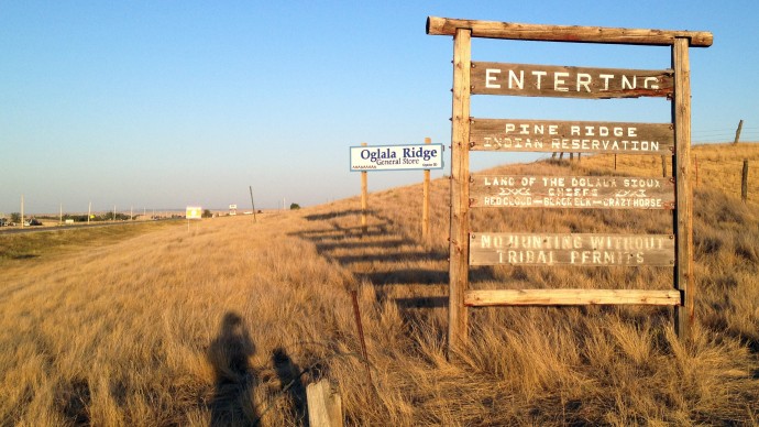 This Sept. 9, 2012, photo shows the entrance to the Pine Ridge Indian Reservation in South Dakota. The reservation, home to the Oglala Sioux Tribe, has been getting lots of media attention lately. But some tribal members both on and off the reservation think the stories are exploitative, with too little emphasis on the people who are working every day to try to make a difference. (AP Photo/Kristi Eaton)
