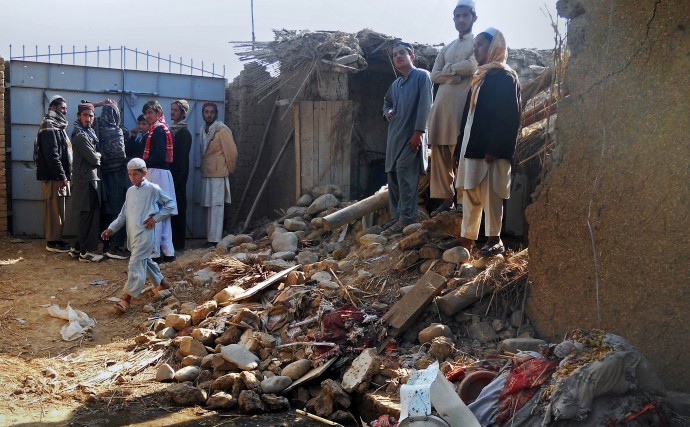 Muslim students stand in the rubble of an Islamic seminary that was hit by a suspected U.S. drone strike in Hangu district in Pakistan's Khyber Pakhtunkhwa province, Thursday, Nov. 21, 2013. A suspected U.S. drone carried out a rare missile strike in northwest Pakistan outside the country's remote tribal region on Thursday, killing some people, including three Afghan militants, Pakistani police and security officials said. (AP Photo/Abdul Basit)