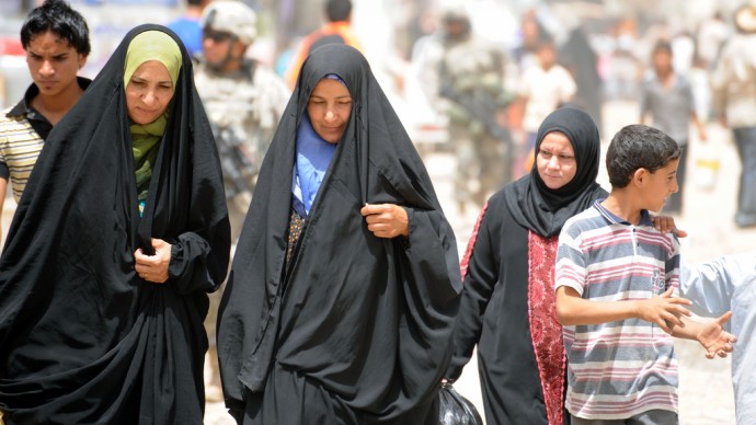 Iraqi women walk down a busy market street in eastern Baghdad, Iraq, June 21, 2009.  U.S. Soldiers of Alpha Company, 2nd Battalion, 505th Parachute Infantry Regiment, 3rd Brigade Combat Team, 82nd Airborne Division, check on the progress of civil improvement projects in the area. (Photo by Staff Sgt. James Selesnick)