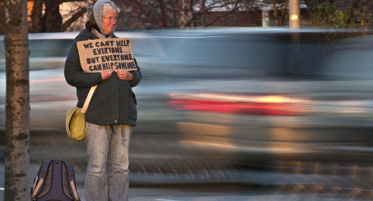 Susan St. Amour, 54, a homeless woman, panhandles during the evening commute, Thursday, Nov. 14, 2013, in Portland, Maine. (AP Photo/Robert F. Bukaty)