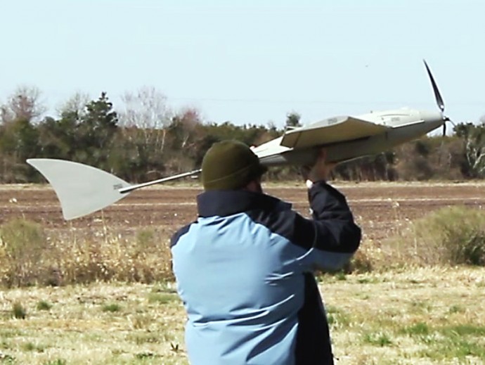 In this March 21, 2013, photo provided by the North Carolina Department of Transportation, a technician from BOSH Technologies prepares to launch a remotely-piloted aircraft during the first test flight at Hyde County Airport in Engelhard, N.C. A little-noted provision in North Carolina’s budget bans police and other government agencies to buy surveillance drones for the next two years as state lawmakers study the balance between security and privacy. (AP Photo/North Carolina Department of Transportation)