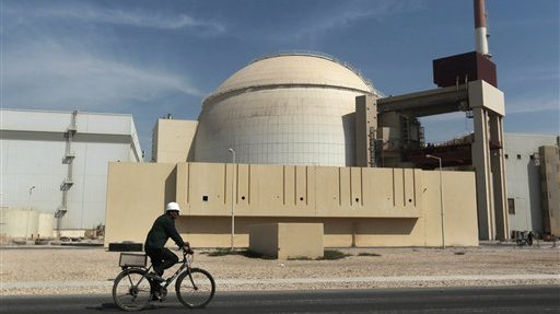A worker rides a bicycle in front of the reactor building of the Bushehr nuclear power plant