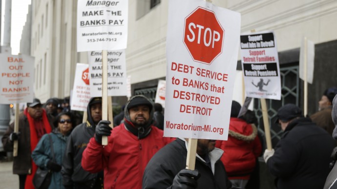 Detroit city workers and supporters protest outside the federal courthouse in Detroit while awaiting the bankruptcy decision, Tuesday, Dec. 3, 2013. A judge is expected to announce Tuesday if the city is to become the biggest city in U.S. history to enter bankruptcy. (AP Photo/Carlos Osorio)