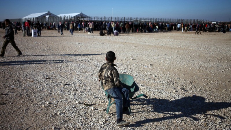 A Syrian refugee boy uses a wheelbarrow to transport gas cylinders and heaters distributed by the Norwegian Refugee Council's (NRC) distribution center, at Zaatari refugee camp, near the Syrian border in Mafraq, Jordan, Monday, Dec. 16, 2013. (AP Photo/Mohammad Hannon)