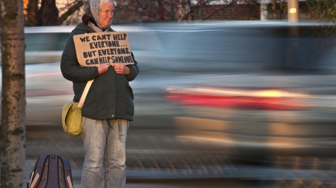 Susan St. Amour, 54, a homeless woman, panhandles during the evening commute, Thursday, Nov. 14, 2013, in Portland, Maine. A one-day trial is being held next week for a lawsuit filed by the ACLU challenging Portland's new panhandling law on grounds that it's infringement on free speech. (AP Photo/Robert F. Bukaty)