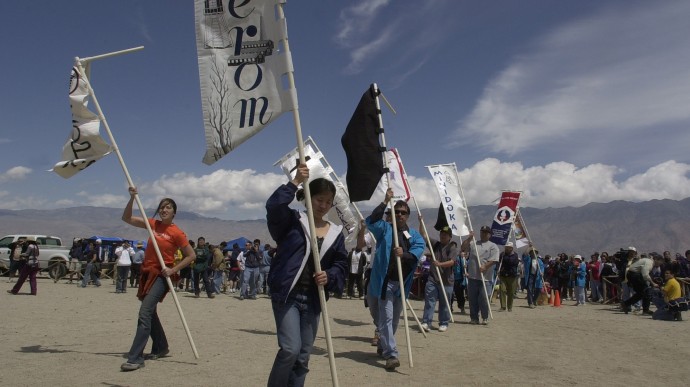 A procession of banners with the names of the 10 World War II internment camps begin a memorial ceremony Saturday April 27, 2002 at the Manzanar National Historic Landmark near Lone Pine, Calif.  About 1,000 people took part in a pilgrimage at the site to mark the 60th anniversary of the order that sent Americans of Japanese descent to the internment camp at Manzanar and to other camps during World War II. (AP Photo/Joe Cavaretta)
