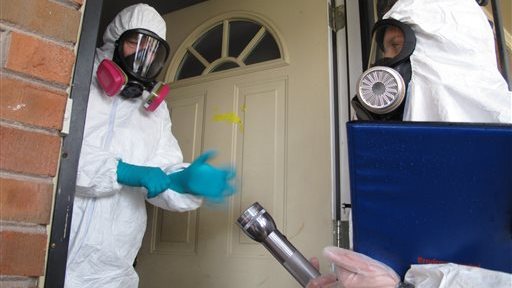 This Nov. 25, 2013 photo shows certified industrial hygienist Gary Siebenschuh, left, and assistant Courtney Van Stolk preparing to enter a house that was once used as a clandestine methamphetamine lab in Memphis, Tenn. The house was placed under quarantine after a Nov. 6 fire that police said was caused by a meth lab that exploded in the attic of the house. Siebenschuh and Van Stolk were hired by the homeowner to test the home for meth residue. (AP Photo/Adrian Sainz).