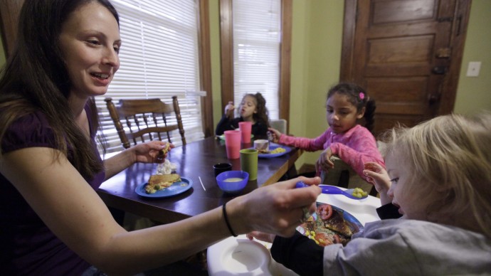 In this photo taken  Lisa Zilligen, 28, serves lunch to her three children, Miles, 20 months, Olivia 6, left, and Danielle, 8, in her home. Zilligen, a single mother and full time student at Loyola University has been getting food stamps for the past several months; sometimes the allotment runs out before the end of the month and the family ends up visiting a food pantry. (AP Photo/M. Spencer Green)