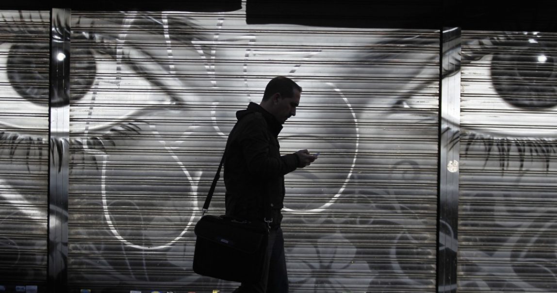 A man looks at his cell phone as he walks on the street in downtown Madrid, Thursday, Oct. 31, 2013.(AP Photo/Francisco Seco)