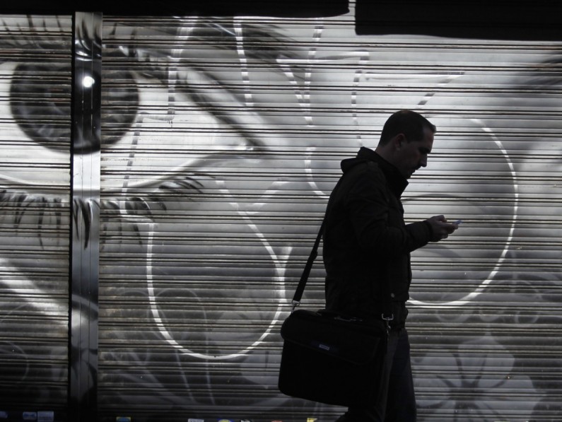 A man looks at his cell phone as he walks on the street in downtown Madrid, Thursday, Oct. 31, 2013. On Wednesday Spain's Prime Minister Mariano Rajoy said that the head of Spain's intelligence services will address Parliament over allegations that Spain was a target for surveillance by the U.S. National Security Agency. He reiterated that if confirmed, such activity is “inappropriate and unacceptable between partners and friends.” (AP Photo/Francisco Seco)