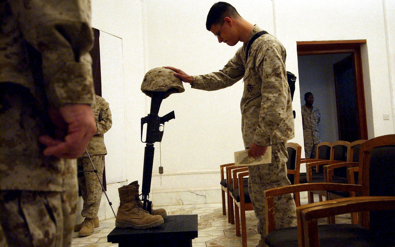 U.S. Marines pay their final respects at a memorial service for 1st Marine Division Combat Photographer Cpl. William Salazar, 26, of Las Vegas, NV, at Camp Blue Diamond, on the outskirts of Ramadi, Iraq. (AP Photo/Jim MacMillan)